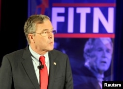 FILE - Former U.S. Republican presidential candidate Jeb Bush stands in front of a photo of former president and brother George W. Bush as he speaks at the New Hampshire GOP's FITN Presidential town hall in Nashua, New Hampshire, Jan. 23, 2016.
