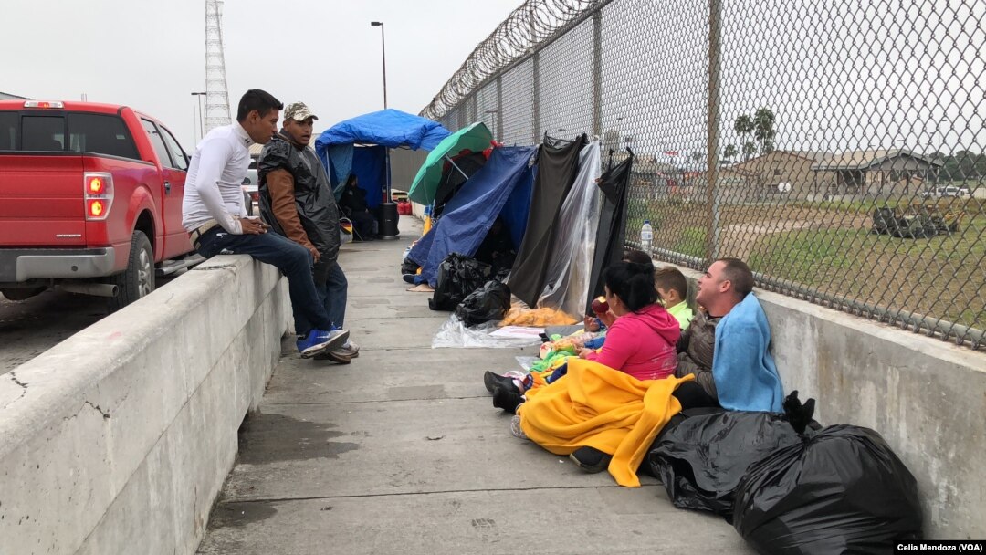 Migrants from Venezuela, Cuba and Guatemala wait at bridge between Matamoros, Mexico and Brownsville, Texas for immigration officials to allow them to turn themselves in and ask for asylum in US, Nov. 12, 2018.