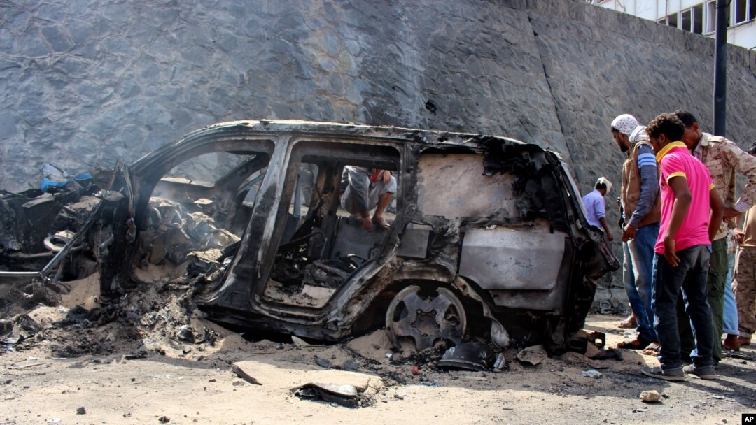 FILE - Yemenis inspect the scene of a car bomb attack that killed a Yemeni senior official in the southern port city of Aden, Yemen, Sunday, Dec. 6, 2015.