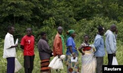FILE - Malawians queue for food aid distributed by the United Nations World Food Progamme (WFP) in Mzumazi village near the capital Lilongwe, Feb. 3, 2016.