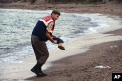 A paramilitary police officer carries the lifeless body of a migrant child after a number of migrants died and a smaller number were reported missing after boats carrying them to the Greek island of Kos capsized, near Bodrum, Sept. 2, 2015.