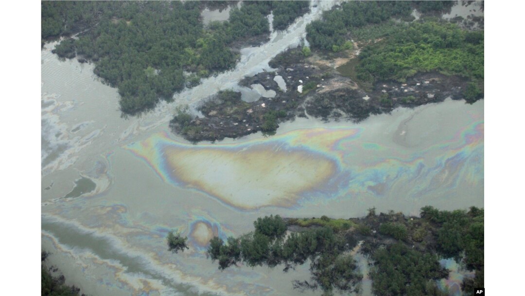 FILE -Oil is seen on the creek water's surface near an illegal oil refinery in Ogoniland, outside Port Harcourt, in Nigeria's Delta region, March 24, 2011.