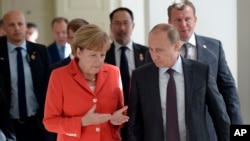 Russian President Vladimir Putin and German Chancellor Angela Merkel speak to each other before the World Cup final between Germany and Argentina in Rio de Janeiro, Brazil.
