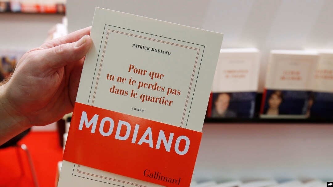 A man holds a book by French author Patrick Modiano at a book fair in Frankfurt, Germany, Oct. 9, 2014.