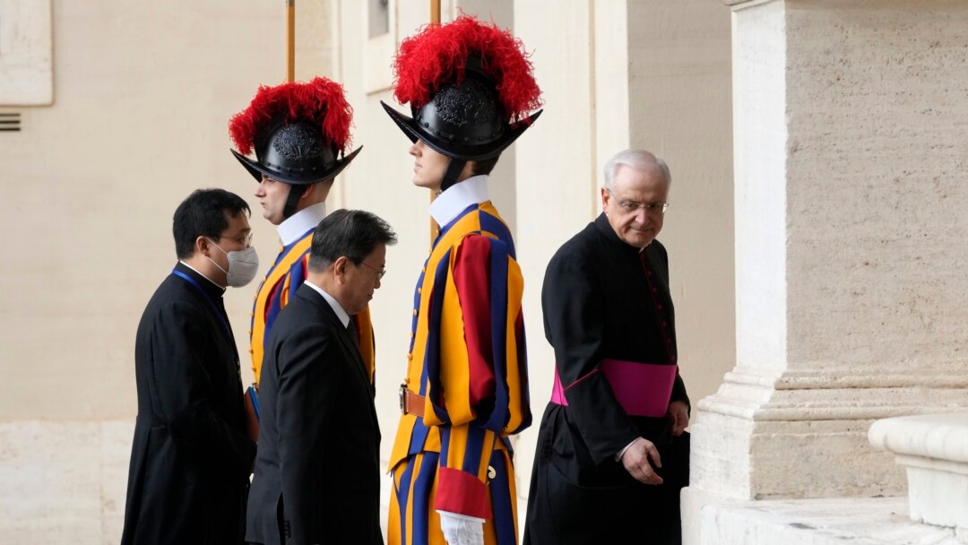 South Korea's President Moon Jae-in, center, is greeted by Head of the Papal Household, Mons. Leonardo Sapienza, right, as he arrives for a meeting with Pope Francis at the Vatican, Oct. 29, 2021.