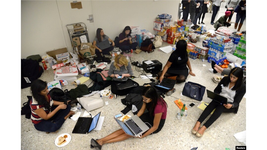 Lawyers and legal assistants network and use social media in the baggage claim area at Dulles International Airport, aiding passengers who have arrived and encounter problems because of Donald Trump's travel ban to the United States, Jan. 29, 2017.