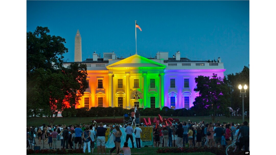 FILE - people gather in Lafayette Park to see the White House illuminated with rainbow colors in commemoration of the Supreme Court's ruling to legalize same-sex marriage in Washington.