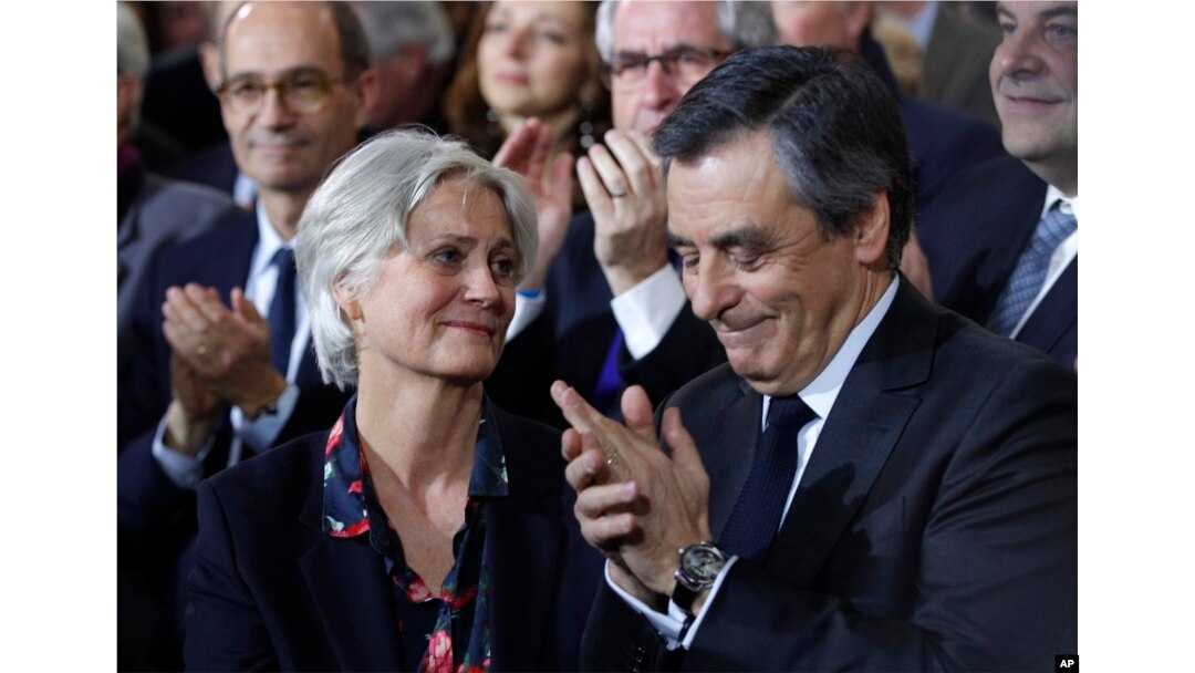 FILE - Conservative presidential candidate Francois Fillon applauds while his wife, Penelope, looks on as they attend a campaign meeting in Paris, Jan. 29, 2017.