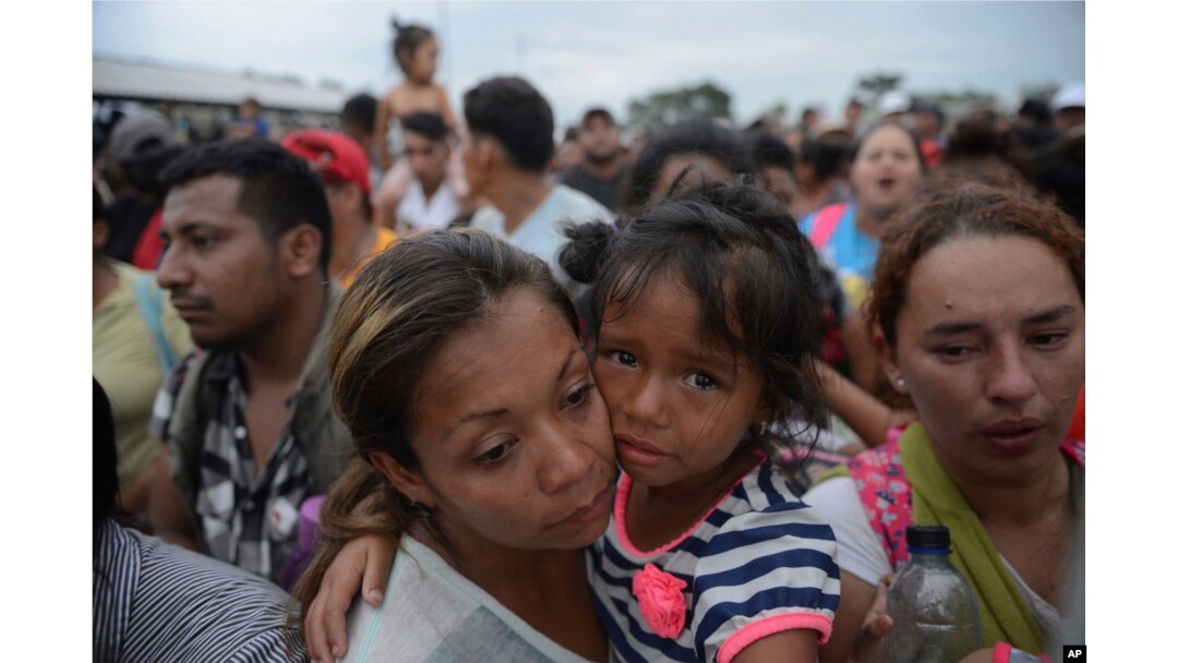 Migrants bound for the U.S.-Mexico border wait on a bridge that stretches over the Suchiate River, connecting Guatemala and Mexico, in Tecun Uman, Guatemala, Oct. 19, 2018.