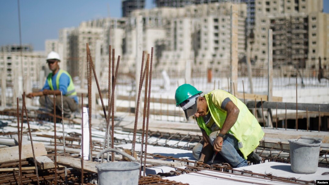FILE - Palestinian laborers work at a construction site in the new Palestinian town dubbed Rawabi or "The Hills", near the West Bank city of Ramallah, Oct. 27, 2013.