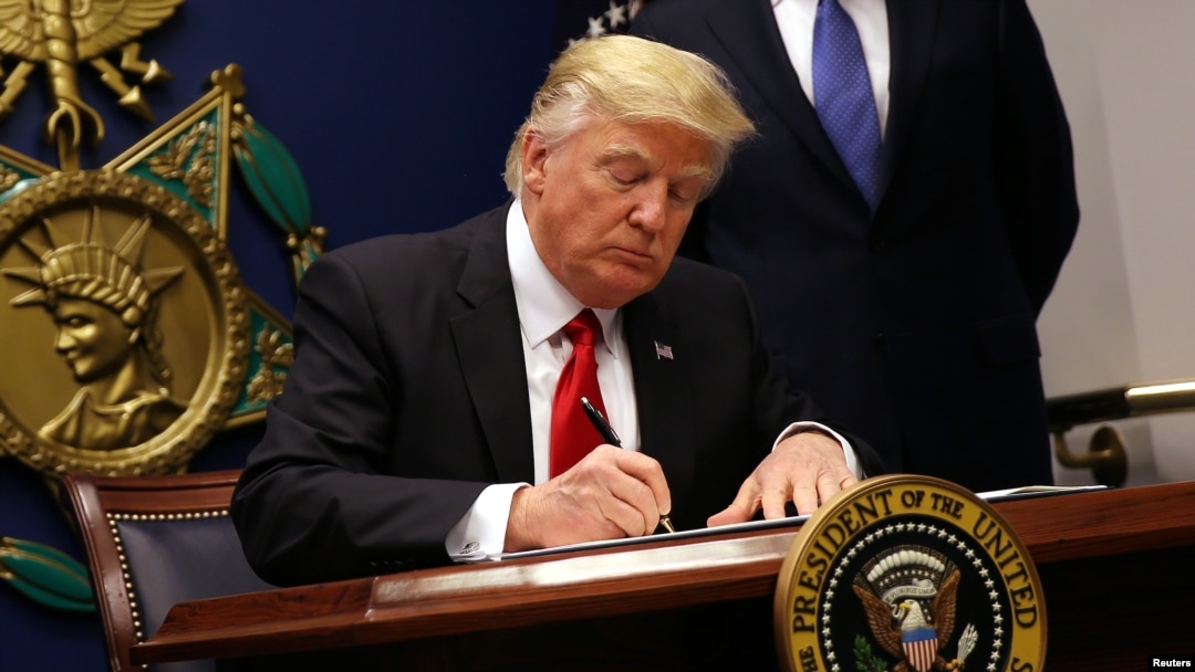 FILE - U.S. President Donald Trump signs an executive order to impose tighter vetting of travelers entering the United States, at the Pentagon in Washington, Jan. 27, 2017. 