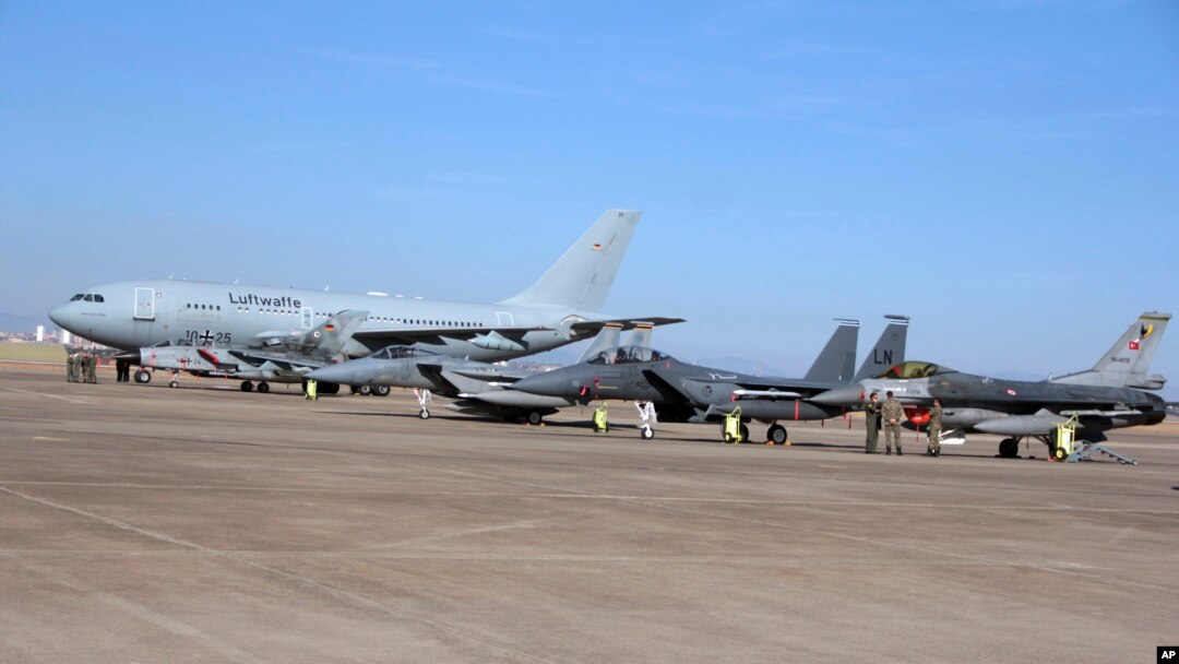 FILE - Turkish, right, and German, left, airmen stand in front of military planes at the Incirlik Air Base near Adana, Turkey, Dec. 15, 2015.