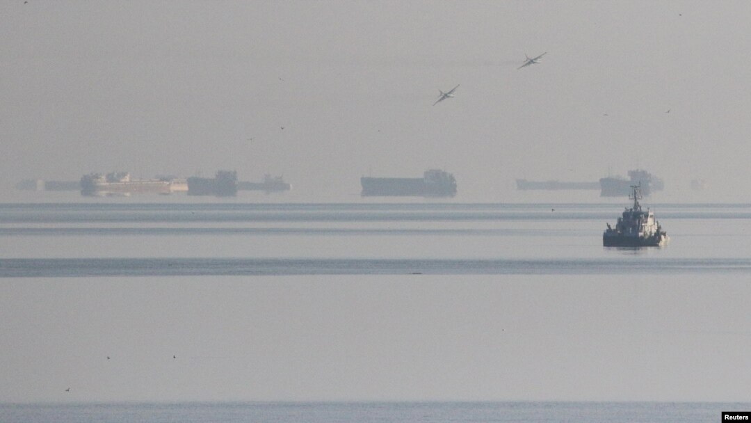 Russian fighter jets fly over vessels after the channel beneath a bridge connecting the Russian mainland with the Crimean peninsula was blocked to stop three Ukrainian navy ships from entering the Sea of Azov, Nov. 25, 2018.