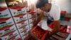 A worker arranges boxes of tomatoes at a warehouse near Alexandria, southern Romania, Aug. 20, 2014. 