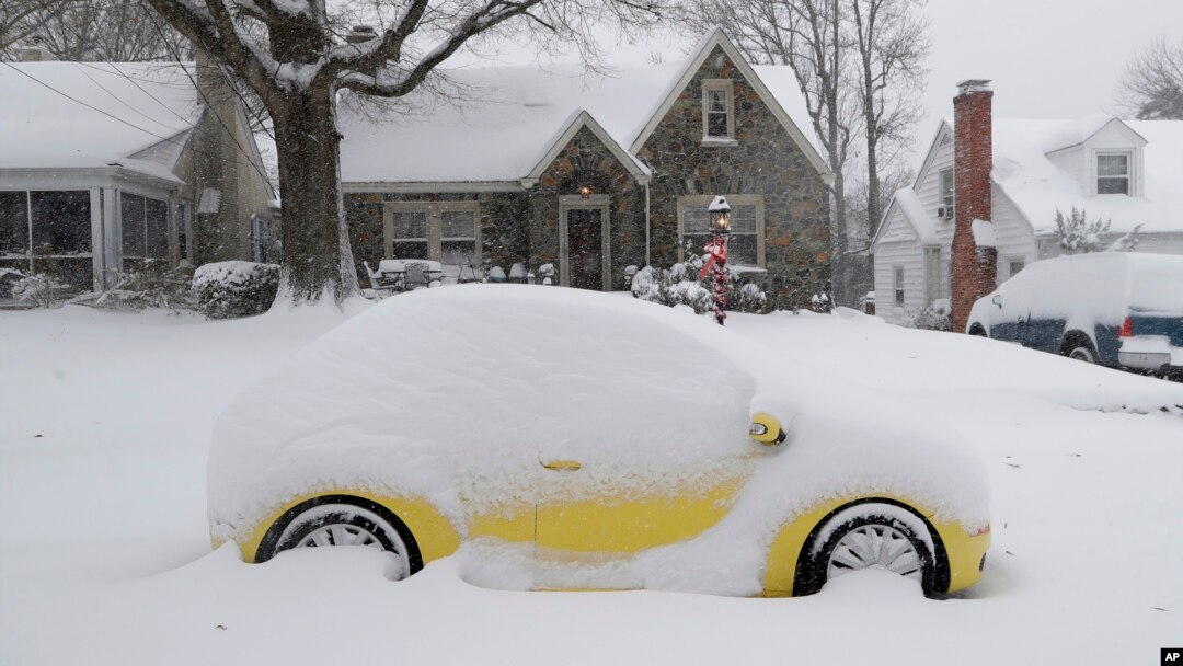 A snow-covered car is parked outside a home in Greensboro, North Carolina, Dec. 9, 2018. A massive storm brought snow, sleet, and freezing rain across a wide swath of the South on Sunday.