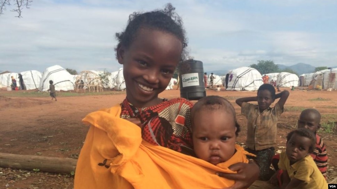 Machi, an Ethiopian refugee in Kenya's Dambala Fachana camp, carries her youngest sister, Lelo. They came to the camp with their family in March. (D. Gelmo/VOA)