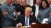 President Donald Trump signs a proclamation on steel imports during an event in the Roosevelt Room of the White House in Washington, March 8, 2018. He also signed one for aluminum.