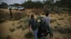 FILE - A U.S. border patrol agent escorts men being detained after entering the United States by crossing the Rio Grande river from Mexico, in Roma, Texas, May 11, 2017.