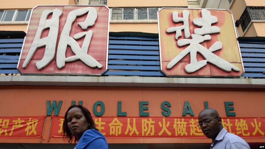 FILE - An African man and woman walk outside a clothing wholesale market in Guangzhou, China, Aug. 26, 2013. 