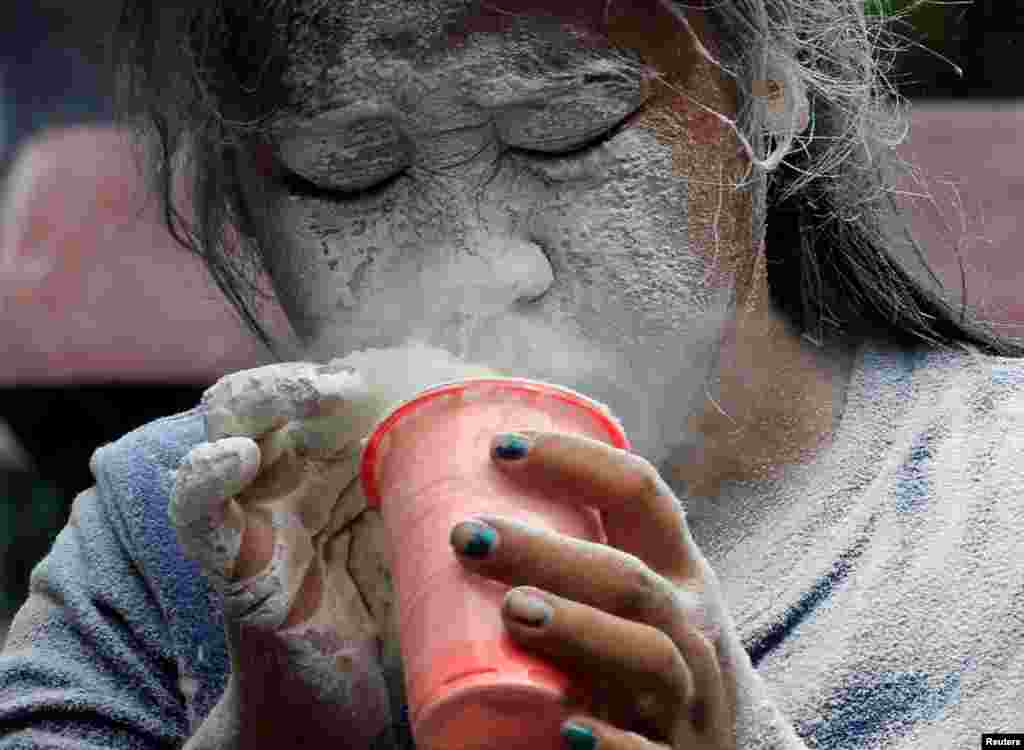 A girl&#39;s face is covered by a white powder after blowing on it during a religious festival honoring patron saint Santa Rita de Cascia in Paranaque city, metro Manila, Philippines.