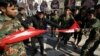 Iraqi Shi'ite protesters tear up a Turkish flag during a rally against Turkey's military presence in northern Iraq, in Basra, Iraq, Oct. 9, 2016.