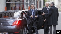 France's President and UMP party candidate for the 2012 French presidential elections Nicolas Sarkozy (L) arrives to attend an interview at the RTL radio station studios in Paris, April 20, 2012. 