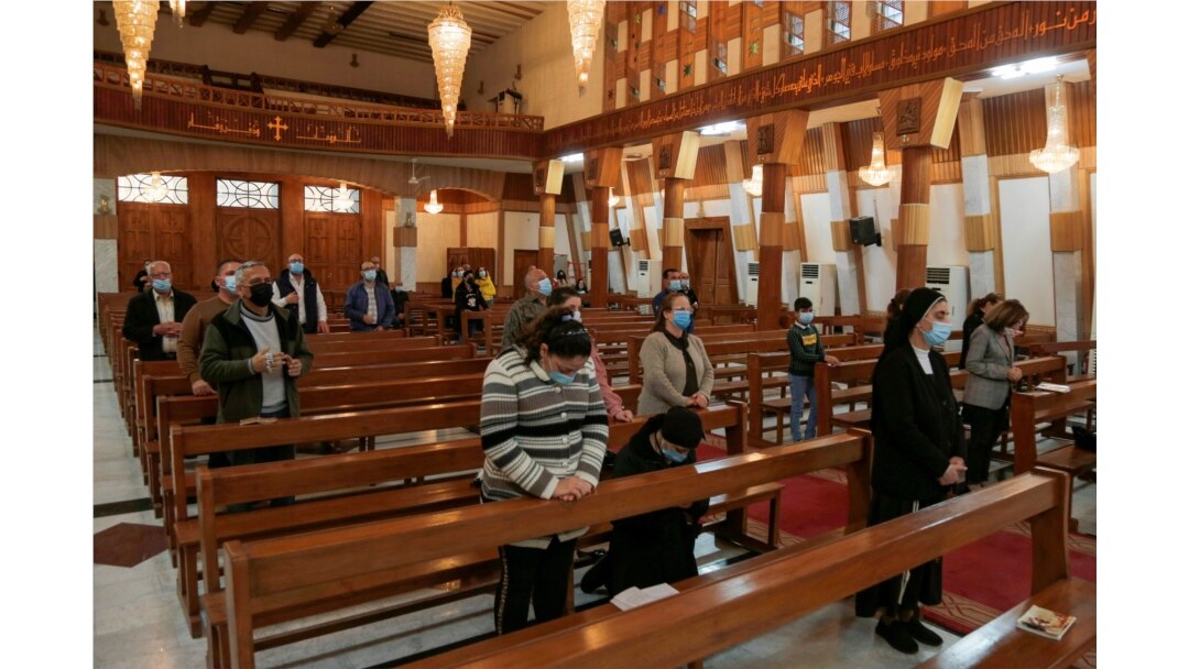Iraqi Christians wear protective face masks, amid the outbreak of the coronavirus disease (COVID-19), as they attend a mass at a Church in Baghdad, Iraq, Feb. 22, 2021.