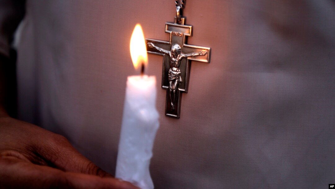 FILE - A Pakistani nun holds a candle during a vigil for victims of a deadly suicide bombing in a park, March 28, 2016, in Lahore. Pakistan's prime minister has vowed to eliminate perpetrators of mass terror attacks.