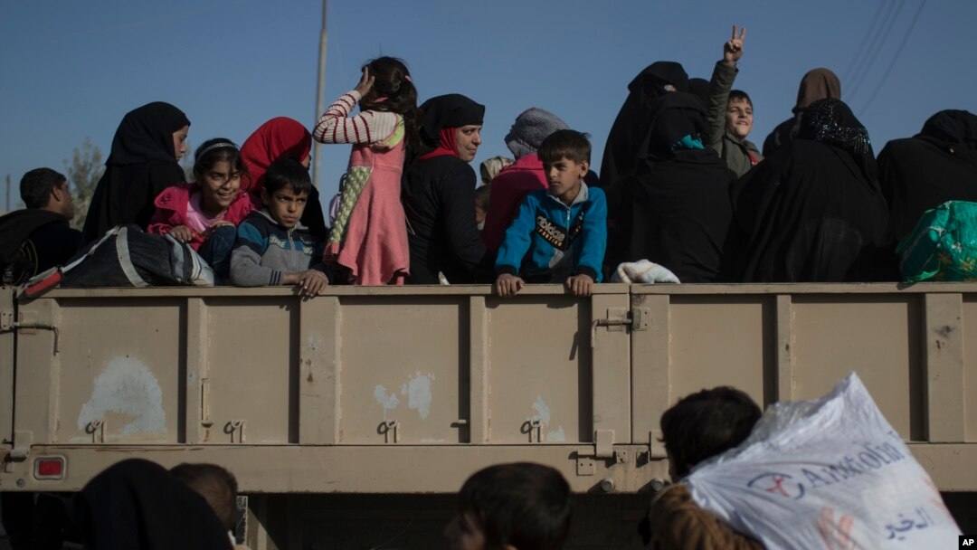 FILE - Women and children displaced by fighting between Iraqi forces and Islamic state militants stand inside a truck as they wait to be taken out of Mosul, Iraq, Nov. 18, 2016. Iraqi authorities have moved hundreds of foreign wives and children of suspected Islamic State militants from a detention center in northern Iraq to Baghdad.