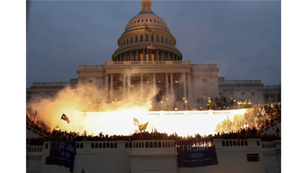 FILE - An explosion caused by a police munition is seen while supporters of U.S. President Donald Trump gather in front of the U.S. Capitol Building in Washington, Jan. 6, 2021.