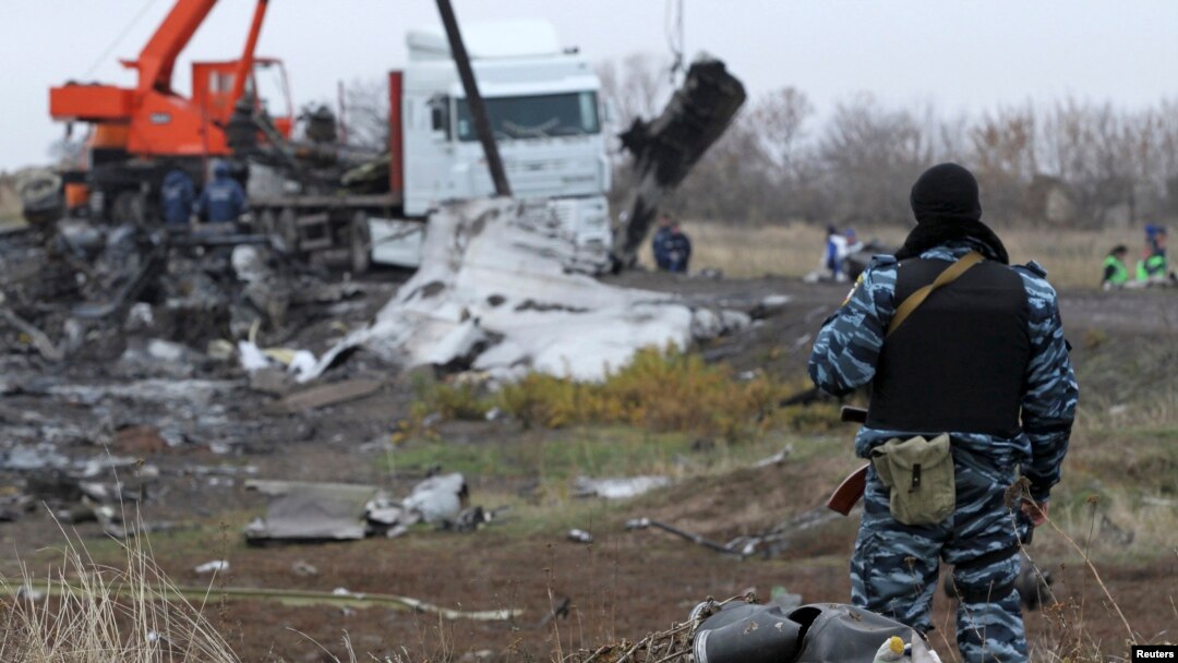 FILE - A pro-Russian armed man secures crash site wreckage of the Malaysia Airlines Flight MH17 at the site of the plane crash near the settlement of Grabovo in the Donetsk region, Nov. 16, 2014. 