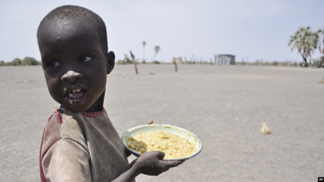 A young boy walks away with his food from a government sponsored feeding center in central Turkana, Kenya, August 30, 2011