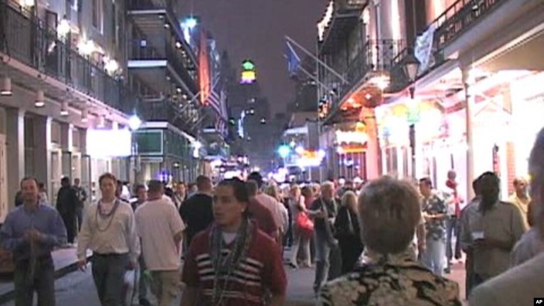 Tourists and locals walk down Bourbon Street in New Orleans