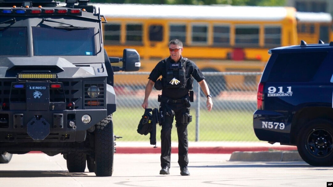 A law enforcement officer walks in the parking lot of Timberview Hight School after a shooting inside the school in south Arlington, Texas, Oct. 6, 2021.