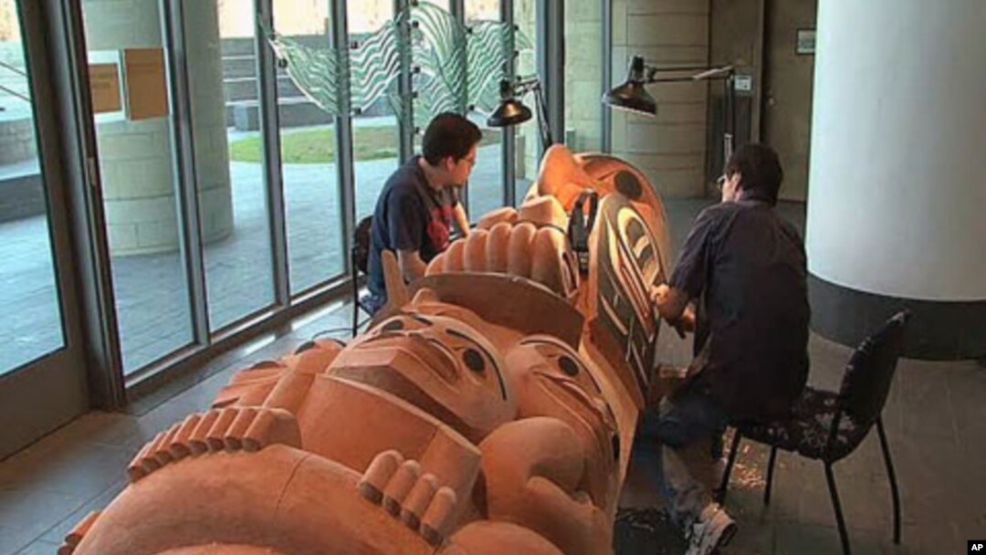 Native American artist David Boxley is from the Tsimshian tribe in Alaska, and he and his son work on one of the many totem poles they have created to keep their native culture alive, at the National Museum of the American Indian in Washington, DC, Januar