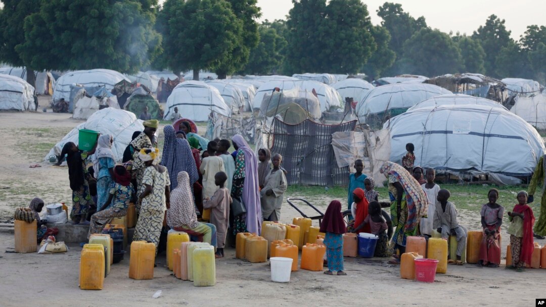 FILE- People displaced by Islamist extremists fetch water at the Muna camp in Maiduguri, Nigeria.
