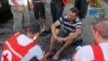 Members of Lebanese Red Cross treat a wounded man after two rockets hit his house in Beirut suburbs, May 26, 2013.