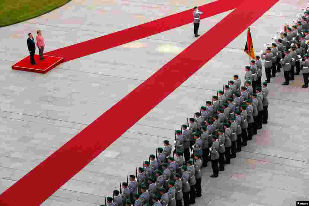 German Chancellor Angela Merkel and Chinese Premier Li Keqiang review the honor guard during a welcome ceremony at the Chancellery in Berlin, Germany.