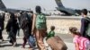FILE - Families walk towards their flight during evacuations at Hamid Karzai International Airport, in Kabul, Afghanistan, Aug. 24, 2021, in this photo provided by the U.S. Marine Corps. (Sgt. Samuel Ruiz/U.S. Marine Corps via AP)