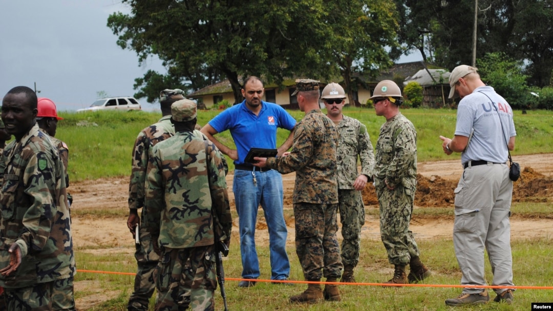 U.S. soldiers and their Liberian counterparts survey a construction site for an Ebola virus treatment center outside Monrovia on Oct. 3, 2014.