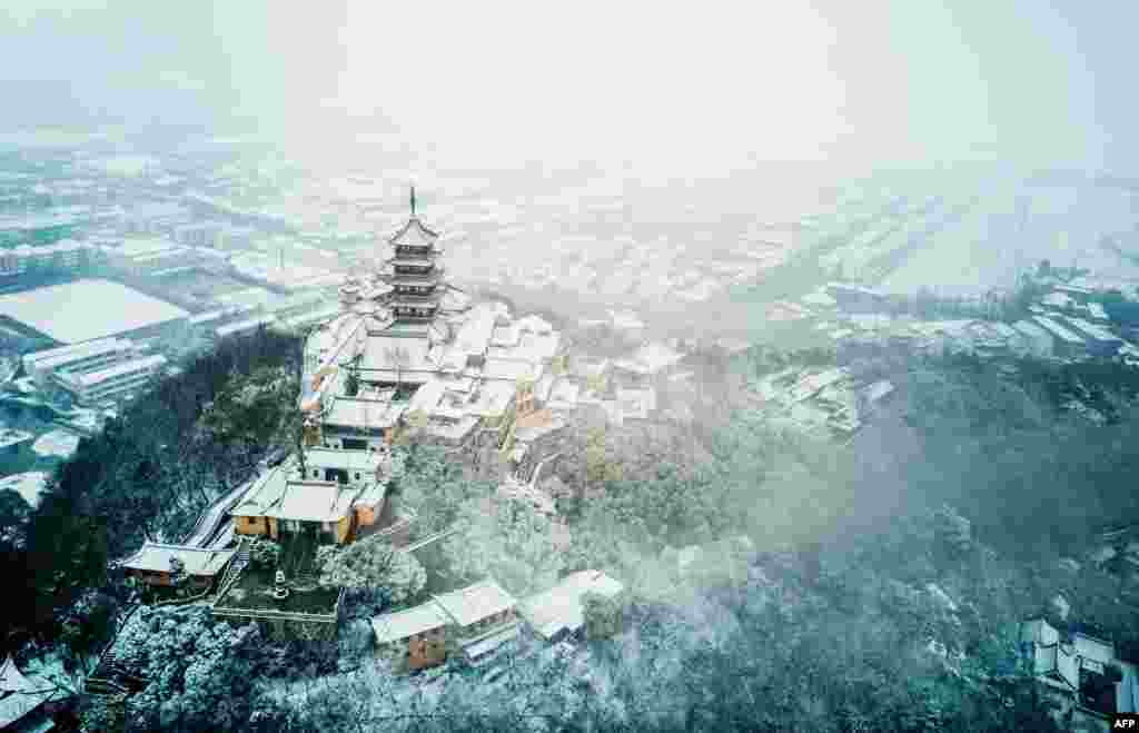 2018年1月25日，中国东部江苏省南通市南郊降雪后的狼山鸟瞰图。狼山是江苏省省级风景名胜区，国家AAAA级旅游区。维基百科说， 根据中国第六次全人口普查，全市常住人口为7282835人。这个数字的出处是南通市统计局 的《南通市2010年第六次全国人口普查主要数据公报》。这个地级市有700多万人。