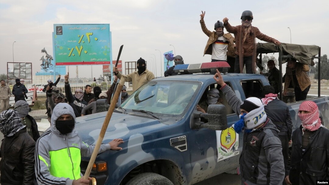 Gunmen takeover a police vehicle in Ramadi, Iraq, Dec. 30 2013.