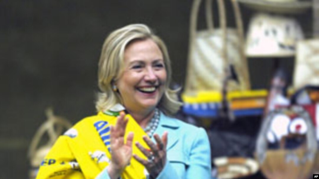 Secretary of State Hillary Rodham Clinton wraps herself with chitenge material after she was presented with it by members of the African Women's Entrepreneurship Program at the Mulungushi International Conference Center in Lusaka, Zambia, Friday, June 10,