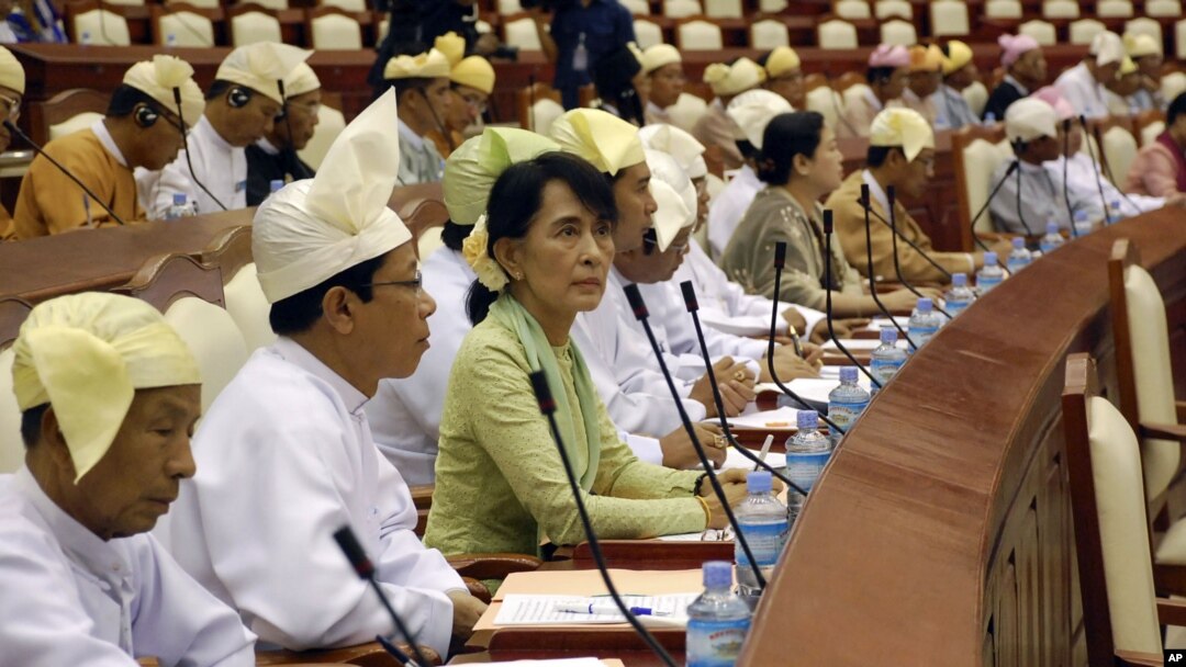 Burma's opposition leader Aung San Suu Kyi, third from left, takes a seat for a regular session of Parliament at Burma's Lower House in Naypyitaw, July 9, 2012.
