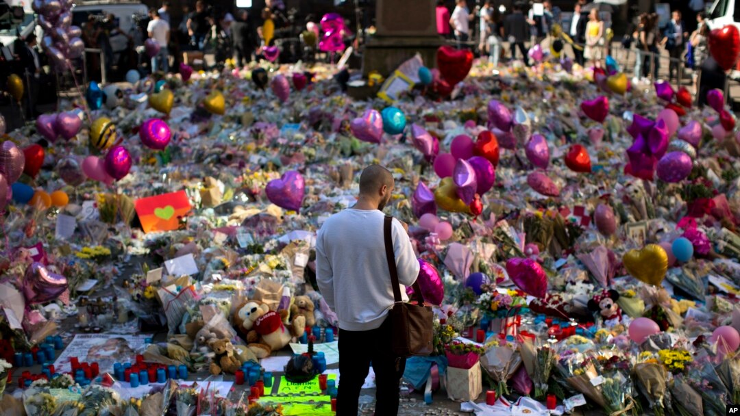 A man stands next to flowers for the victims of Monday's bombing at St Ann's Square in central Manchester, England, May 26, 2017.