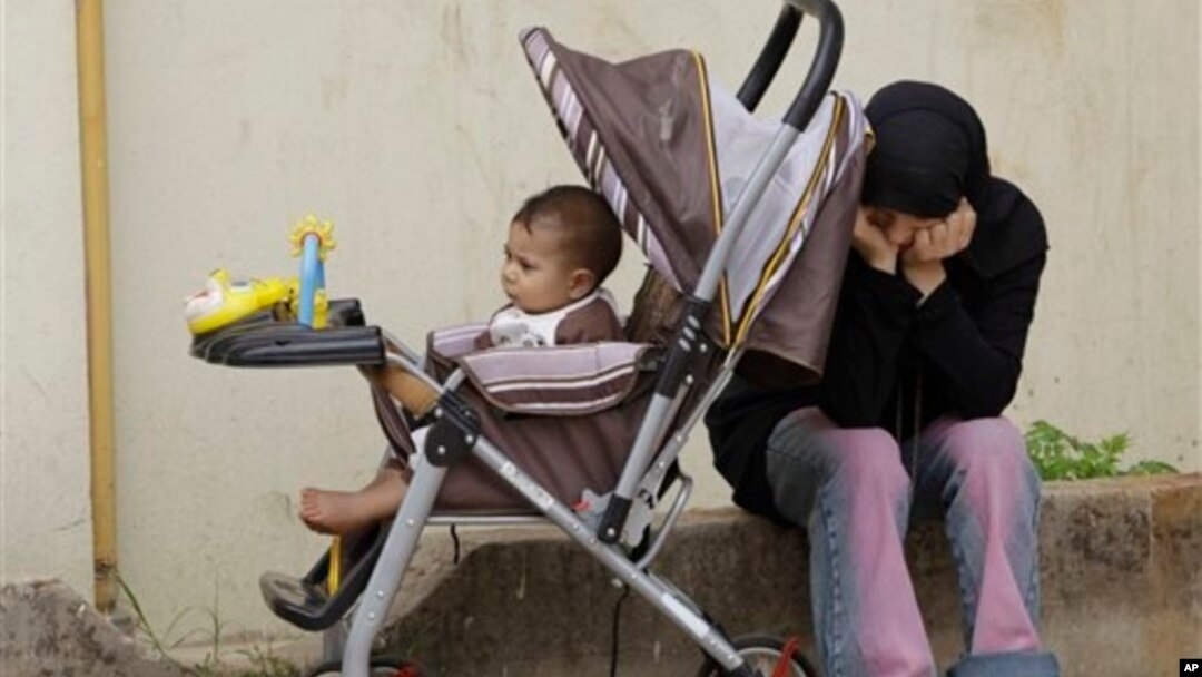 Syrian refugee with her baby near the border town of Wadi Khaled, Lebanon, May 2012.