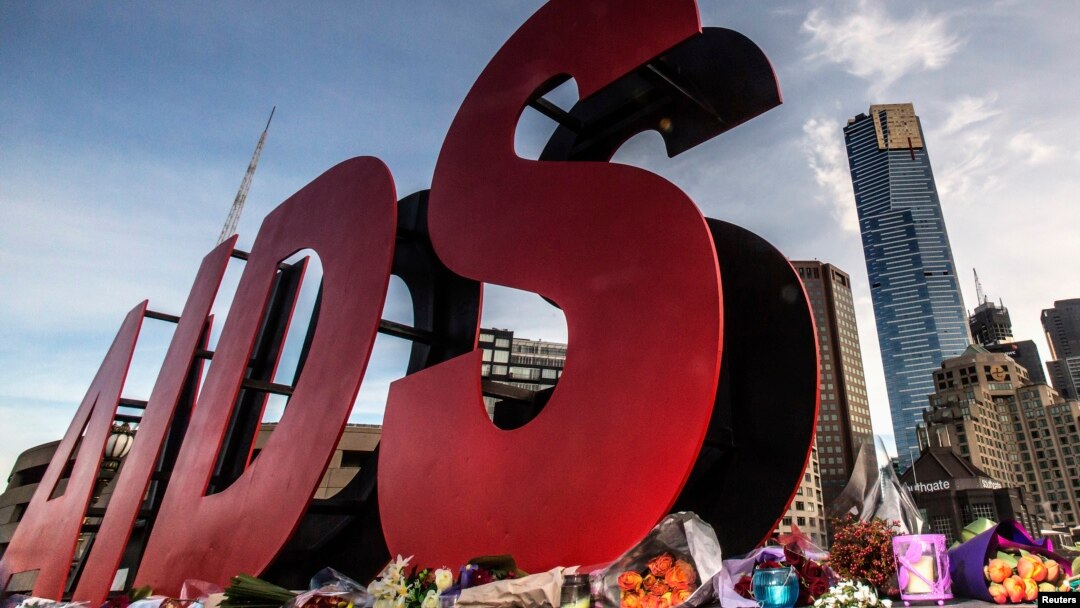 FILE - Flowers are laid as tributes to those killed in the Malaysia Airlines flight MH17, at the base of a large sign for the 20th International AIDS Conference in Melbourne, Australia, July 20, 2014. 