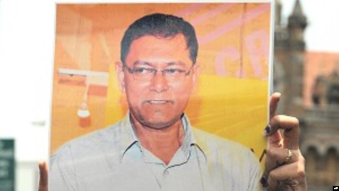 A journalist holds a photograph of slain newspaper crime reporter Jyotirmoy Dey during a protest rally in Mumbai on June 13, 2011.