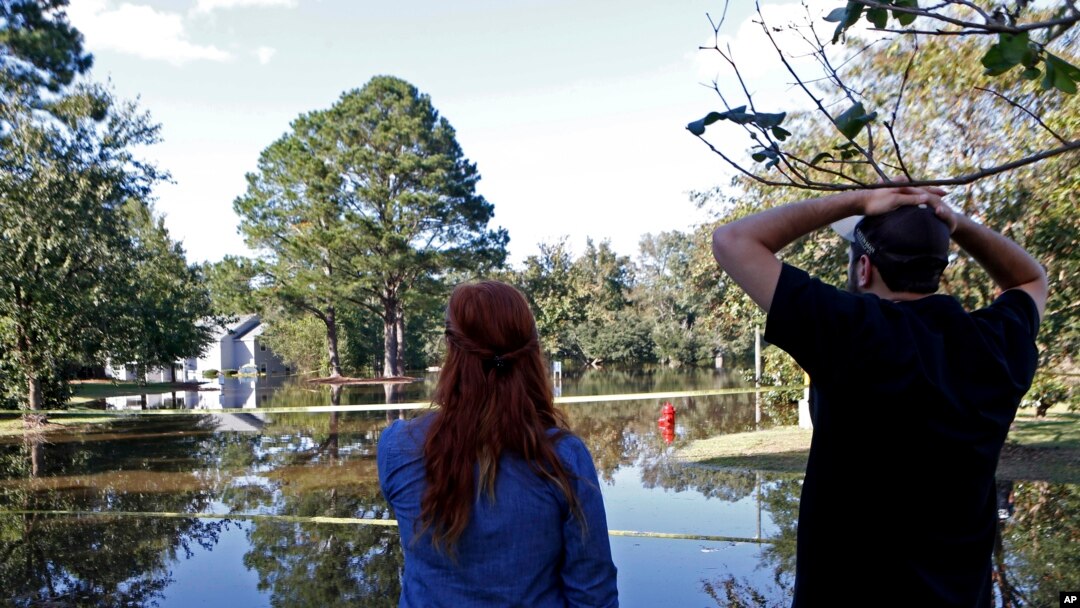 Hurricane Matthew-North Carolina: Caitlyn Cain, left, and friend Sidney Daniels inspect flooding associated with Hurricane Matthew near Cain's old home, Wednesday, Oct. 12, 2016, in Greenville, N.C. 