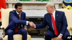 President Donald Trump shakes hands with Qatar's Emir Sheikh Tamim Bin Hamad Al-Thani in the Oval Office of the White House, Tuesday, July 9, 2019, in Washington.